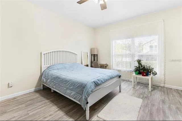 a bedroom with a bed and table chair