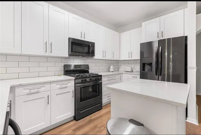 a kitchen with white cabinets and stainless steel appliances
