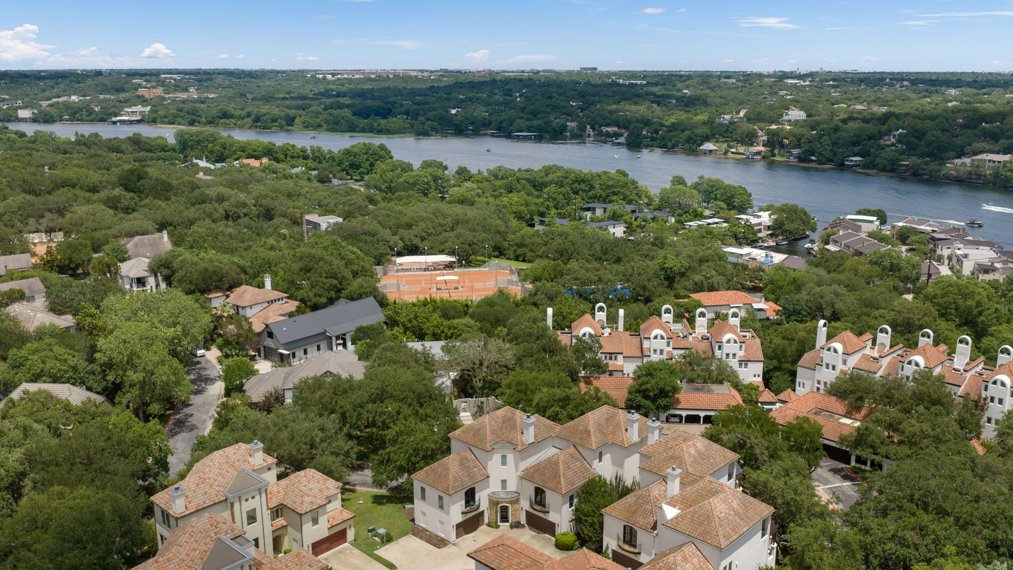 1910 Rue De St Tropez, Unit 6 Austin, TX 78746 - Photo 1 of 37 An aerial perspective reveals a picturesque neighborhood nestled amongst verdant trees, offering stunning views of the nearby river.