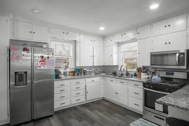 a kitchen with stainless steel appliances a sink a stove a refrigerator and cabinets