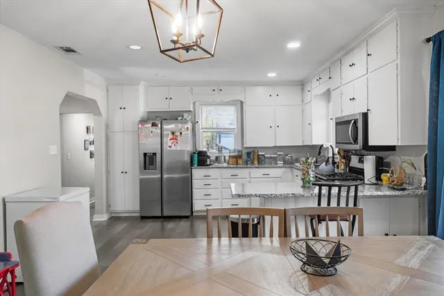 a kitchen with stainless steel appliances granite countertop a stove refrigerator and cabinets