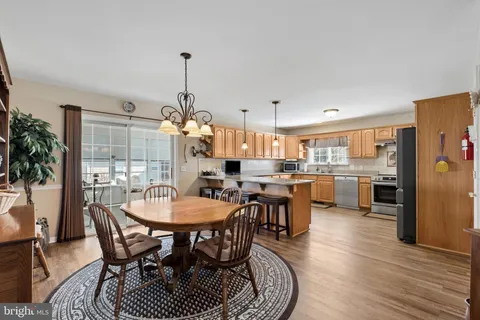 a kitchen with stainless steel appliances granite countertop a refrigerator sink and wooden cabinets