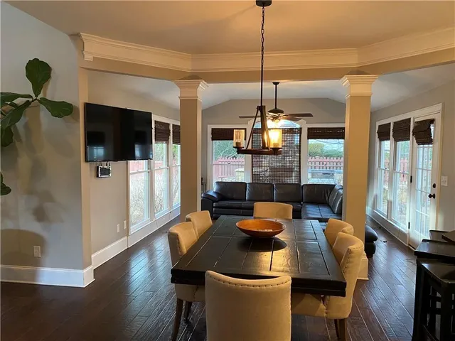 a dining room with furniture a chandelier and wooden floor
