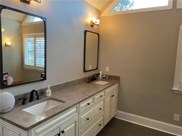 a bathroom with a granite countertop sink vanity and mirror