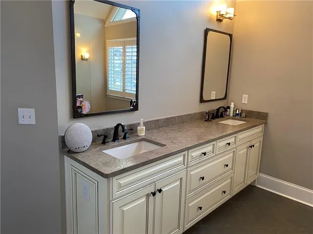 a bathroom with a granite countertop sink and a mirror