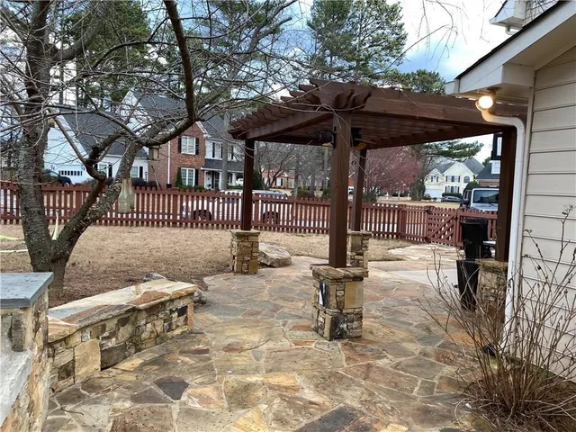 a view of a chair and table in backyard of the house