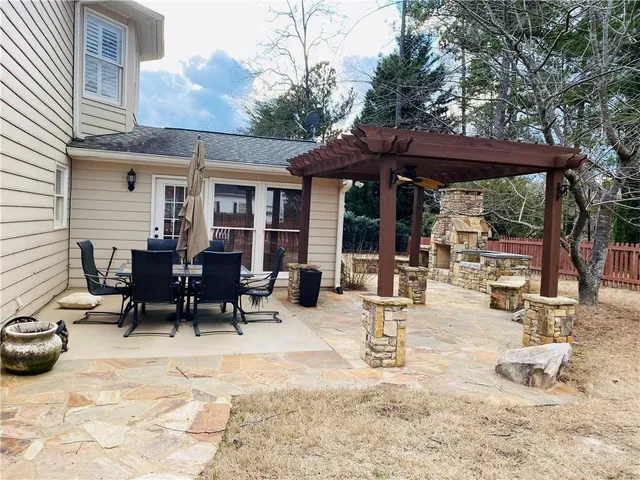 a view of a patio with table and chairs under an umbrella