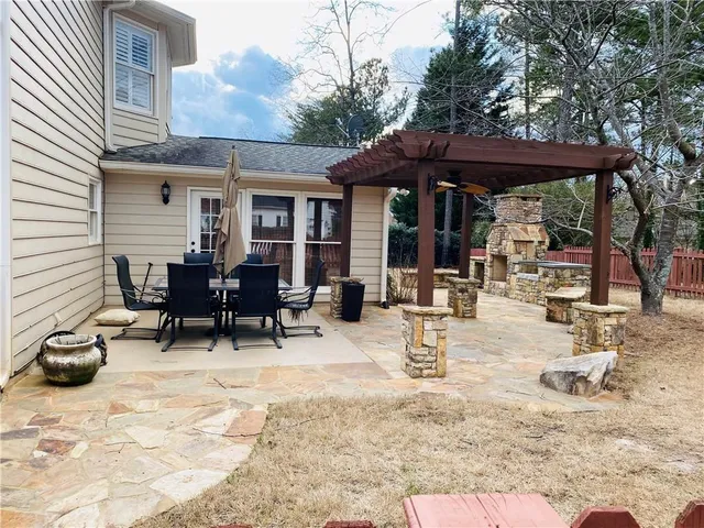 a view of a patio with a table and chairs under an umbrella