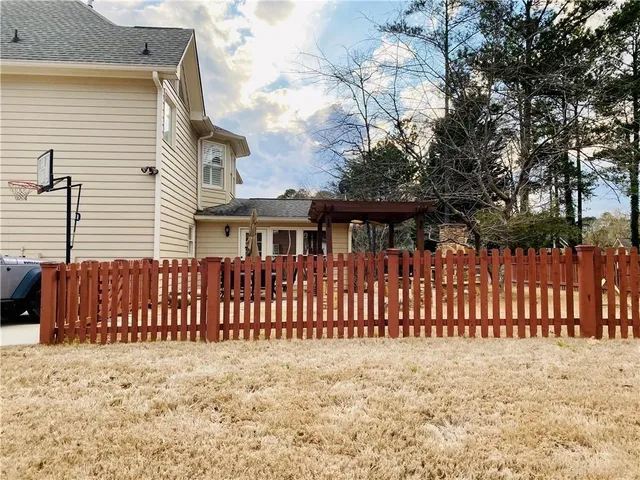 a view of a house with a wooden fence