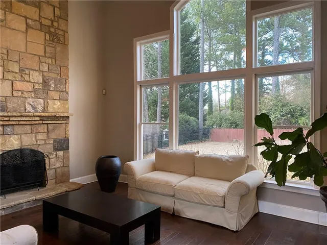 a living room with furniture a fireplace and a floor to ceiling window