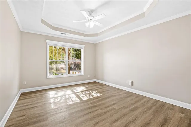 an empty room with windows and ceiling fan