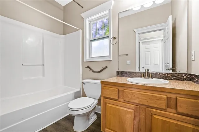 a bathroom with a granite countertop toilet sink and mirror