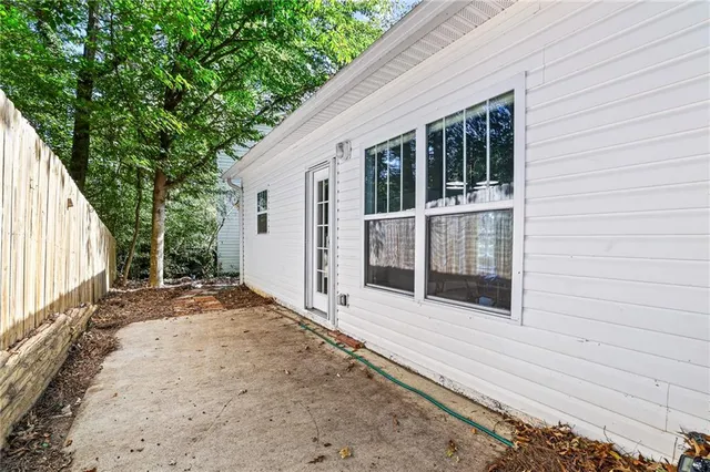 a view of backyard with large trees and wooden fence