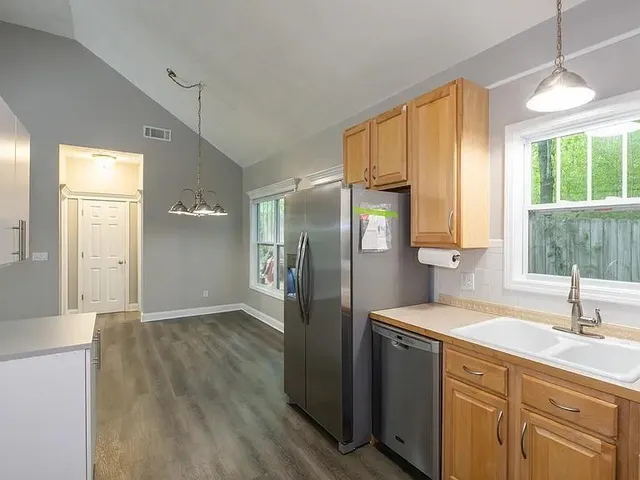 a kitchen with stainless steel appliances granite countertop a refrigerator a sink and a window