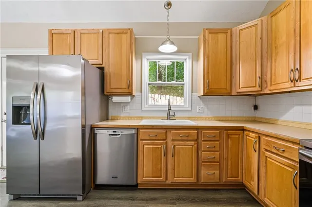 a kitchen with stainless steel appliances granite countertop a refrigerator and a sink