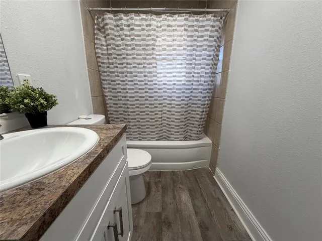 a bathroom with a granite countertop toilet and a sink