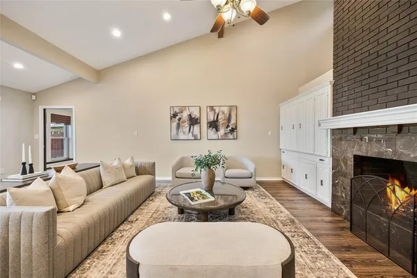 a living room with furniture a fireplace and a chandelier