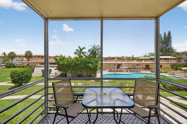 a view of a chairs and table in patio with a lake view