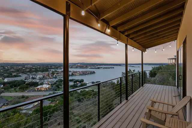 a view of a balcony with wooden floor next to a iron stairs