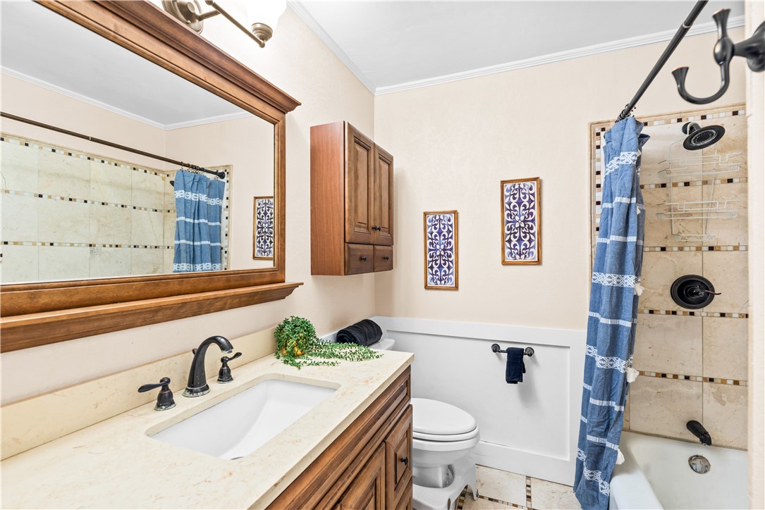 714 Indiana Avenue Corpus Christi, TX 78404 - Photo 24 of 38 a bathroom with a granite countertop sink mirror vanity and toilet