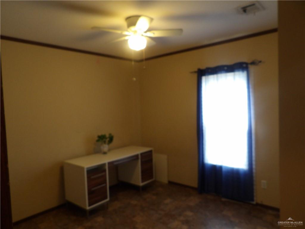 1406 West Ray Circle Mission, TX 78572 - Photo 11 of 22 a room with a bed and a chandelier
