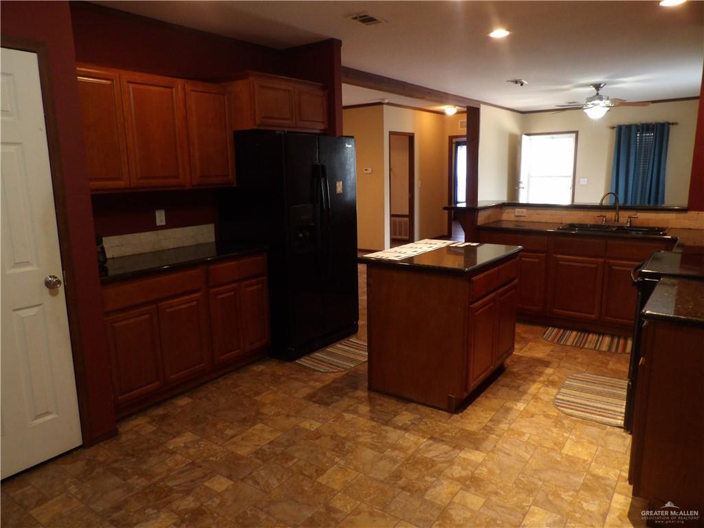 1406 West Ray Circle Mission, TX 78572 - Photo 14 of 22 a kitchen with granite countertop a refrigerator and a stove top oven
