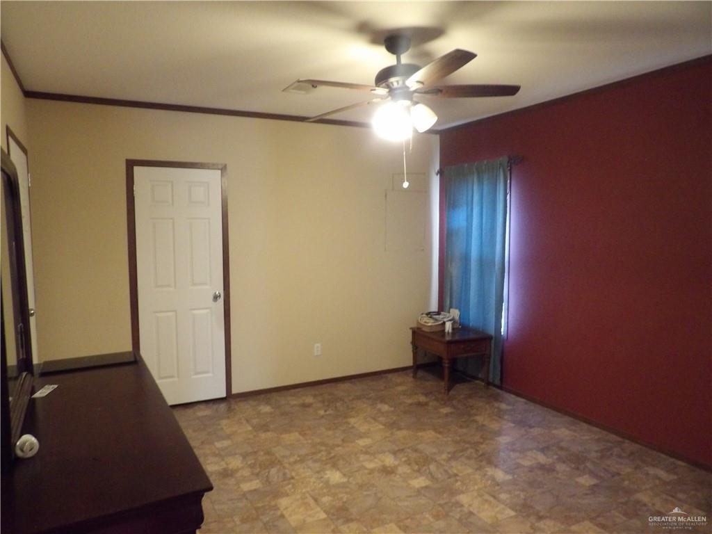 1406 West Ray Circle Mission, TX 78572 - Photo 15 of 22 an empty room with a chandelier fan and wooden floor