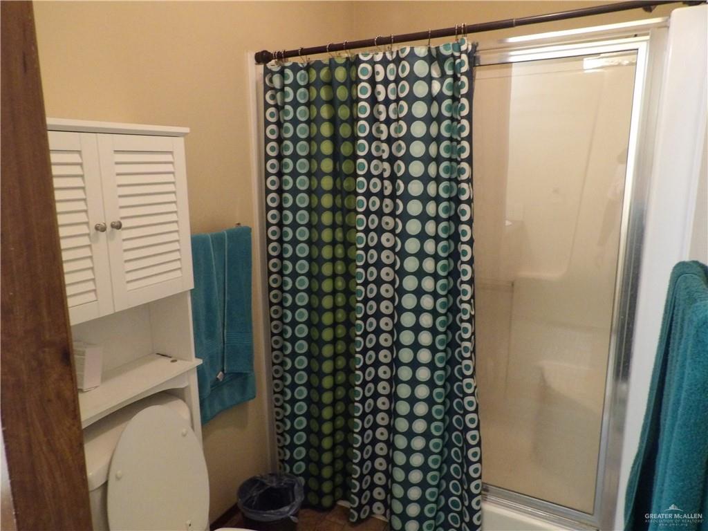 1406 West Ray Circle Mission, TX 78572 - Photo 17 of 22 a bathroom with a shower curtain and a sink
