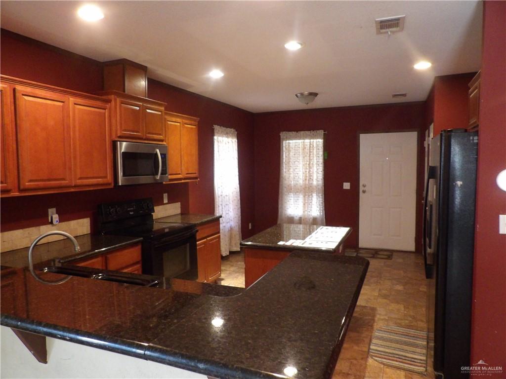 1406 West Ray Circle Mission, TX 78572 - Photo 10 of 22 a kitchen with kitchen island granite countertop a stove and a sink