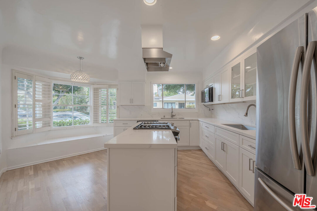 1216 Peck Drive Los Angeles, CA 90035 - Photo 11 of 29 a kitchen with white cabinets and a refrigerator