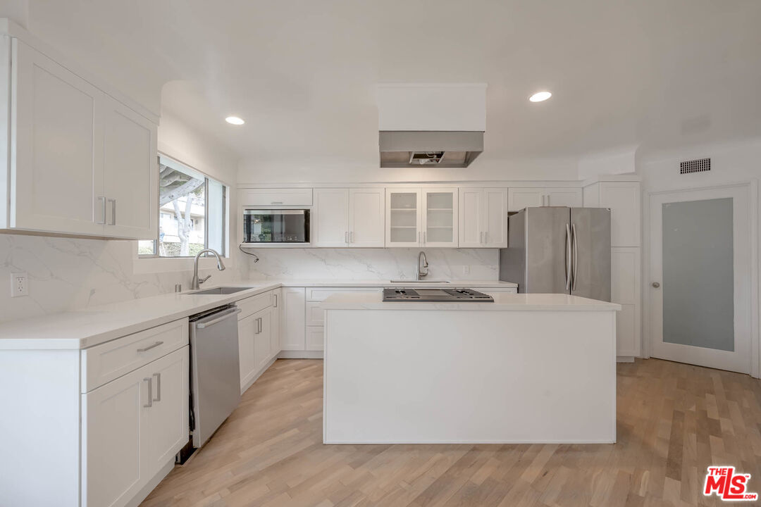 1216 Peck Drive Los Angeles, CA 90035 - Photo 12 of 29 a kitchen with stainless steel appliances a sink stove and refrigerator