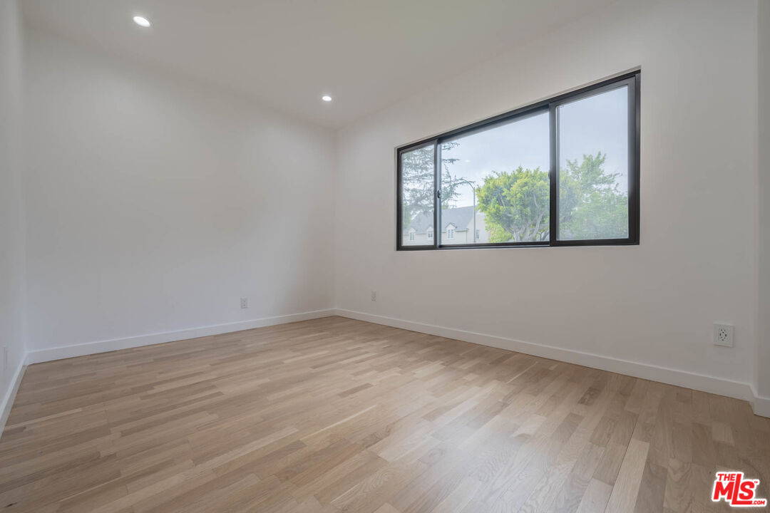 1216 Peck Drive Los Angeles, CA 90035 - Photo 14 of 29 an empty room with wooden floor and windows