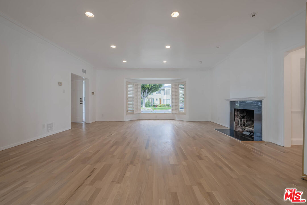 1216 Peck Drive Los Angeles, CA 90035 - Photo 5 of 29 an empty room with windows fireplace and wooden floor
