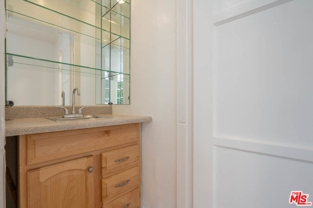 1216 Peck Drive Los Angeles, CA 90035 - Photo 8 of 29 a bathroom with a granite countertop sink and a mirror