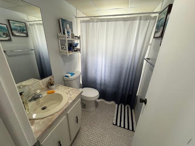 897 Flanders South, Unit 897 Delray Beach, FL 33484 - Photo 13 of 17 a bathroom with a sink a toilet and shower curtain