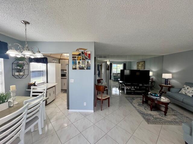 897 Flanders South, Unit 897 Delray Beach, FL 33484 - Photo 2 of 17 a living room with furniture a flat screen tv and kitchen view