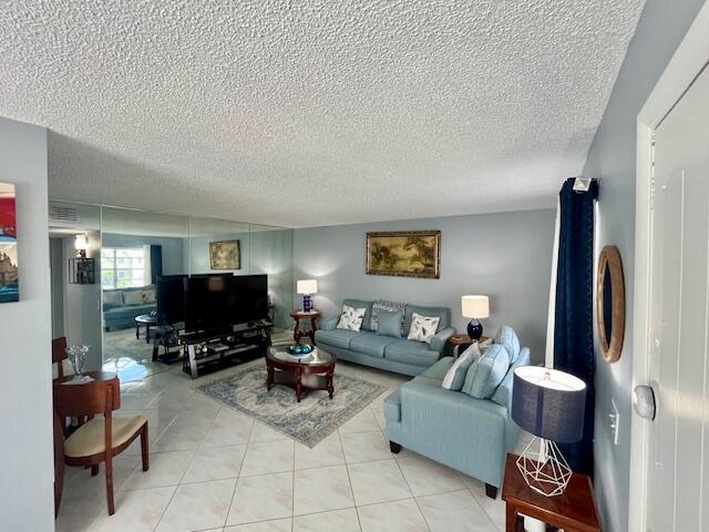 897 Flanders South, Unit 897 Delray Beach, FL 33484 - Photo 5 of 17 a living room with furniture and a flat screen tv