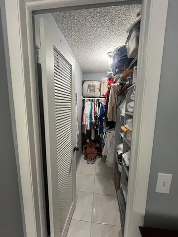a view of walk in closet with clothes