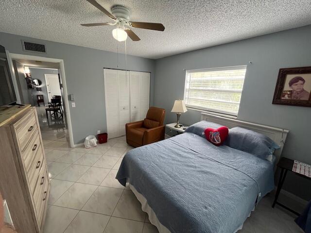 897 Flanders South, Unit 897 Delray Beach, FL 33484 - Photo 9 of 17 a bedroom with a bed and a chandelier
