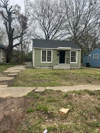 a front view of house with yard and trees around