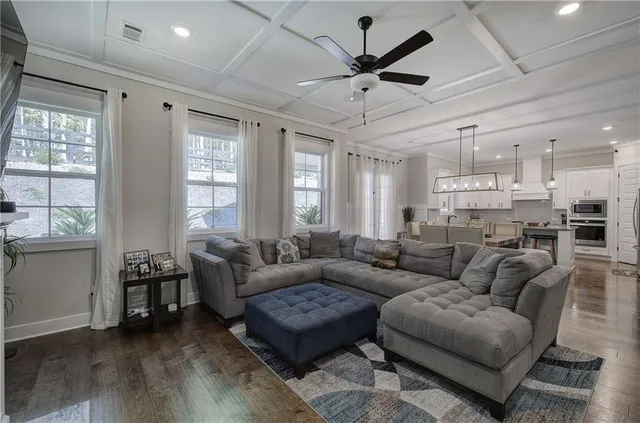 a large kitchen with stainless steel appliances a stove a sink dishwasher and white cabinets with wooden floor