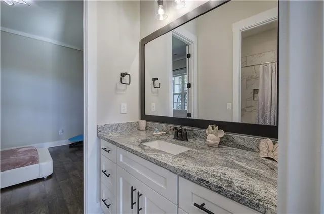 a bathroom with a granite countertop toilet sink and mirror