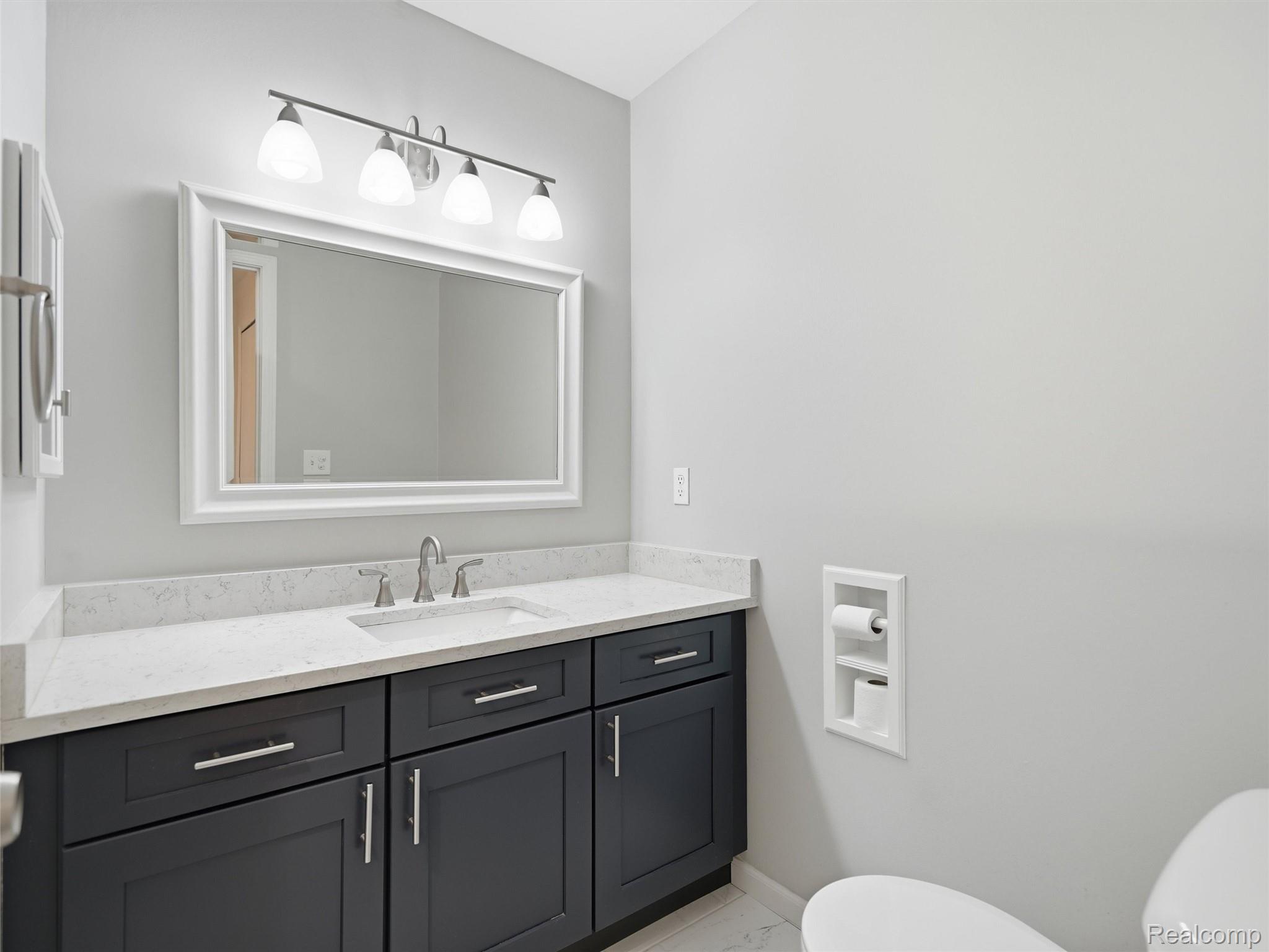 29636 Middlebelt Road, Unit 2602 Farmington, MI 48334 - Photo 23 of 34 Spa-inspired primary bathroom featuring a dark cabinetry vanity with brushed nickel hardware, white quartz countertop, and integrated sink