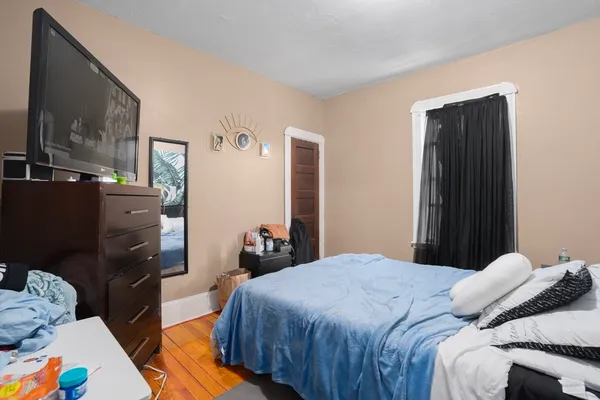 a bedroom with a bed and dresser with mirror