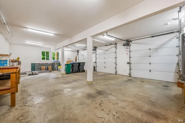 a view of an empty room with window and hardwood floor