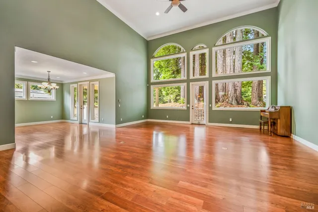 a view of an empty room with window and wooden floor