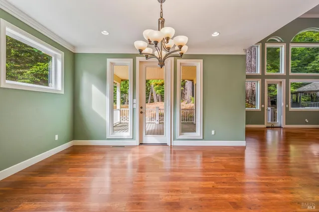 a view of empty room with wooden floor and ceiling fan