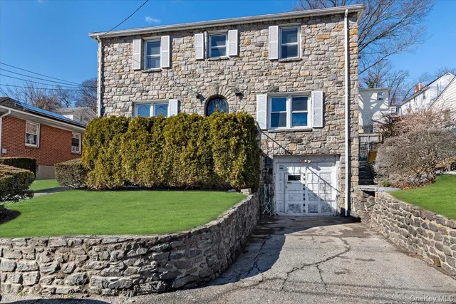 a front view of a house with a garden