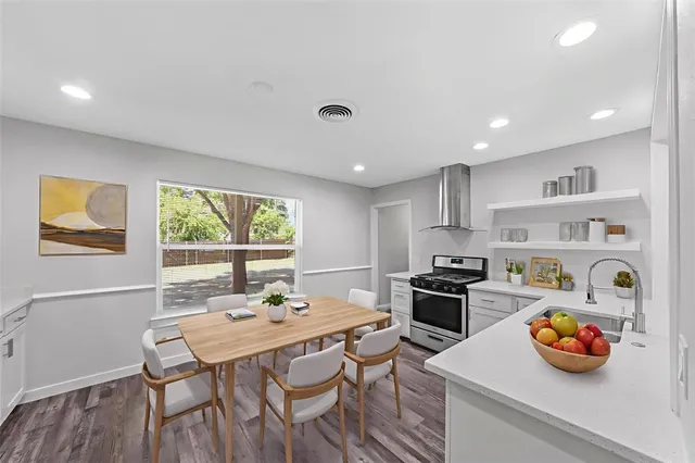 a kitchen with a stove a sink and a window