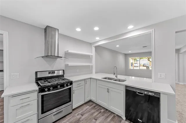 a kitchen with stainless steel appliances granite countertop a stove a sink and a refrigerator